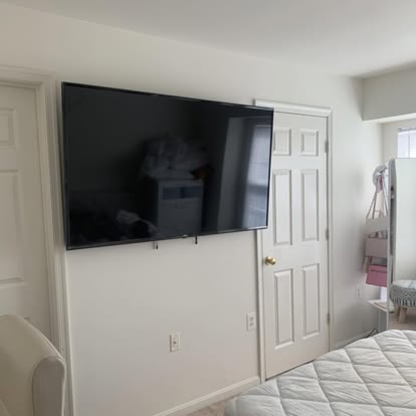 Large flat-screen TV mounted on bedroom wall